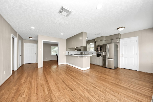 1815 Tannehill Dr, Houston, TX 77008 - kitchen with stainless steel refrigerator with ice dispenser, gray cabinets, light countertops, plenty of natural light, and a textured ceiling