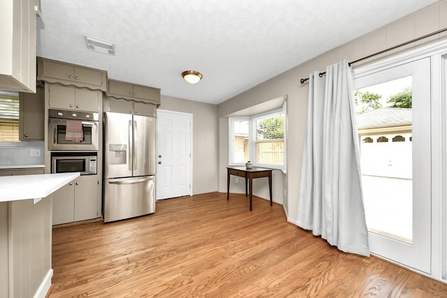 1815 Tannehill Dr, Houston, TX 77008 - kitchen featuring appliances with stainless steel finishes, gray cabinets, light countertops, light wood-type flooring, and baseboards