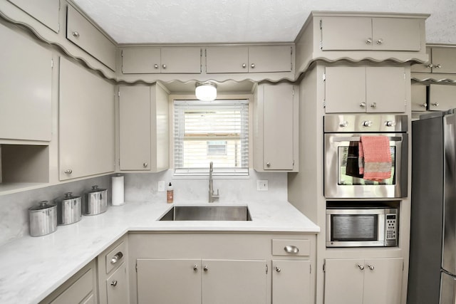 1815 Tannehill Dr, Houston, TX 77008 - kitchen featuring appliances with stainless steel finishes, a sink, light countertops, and a textured ceiling
