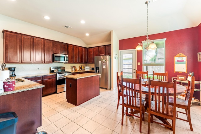9967 Manor Spring Ln, Brookshire, TX 77423 - kitchen featuring stainless steel appliances, lofted ceiling, a center island, pendant lighting, and light stone countertops