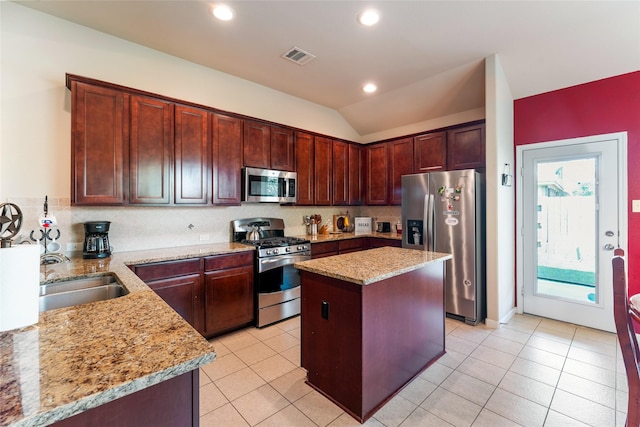 9967 Manor Spring Ln, Brookshire, TX 77423 - kitchen featuring stainless steel appliances, a sink, light stone countertops, vaulted ceiling, and tasteful backsplash