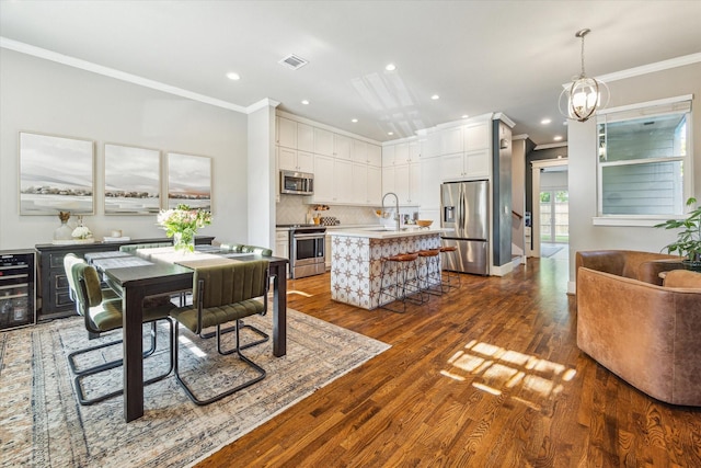 1004 Enid St Unit B, Houston, TX 77009 - dining area with ornamental molding, wine cooler, dark wood-style flooring, recessed lighting, and a chandelier