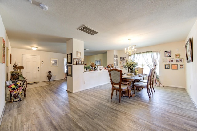 1414 Stevens Ct, Rosenberg, TX 77471 - dining area featuring wood finished floors, a chandelier, baseboards, and a textured ceiling