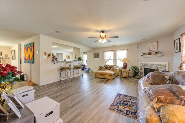 1414 Stevens Ct, Rosenberg, TX 77471 - living area featuring ceiling fan, a stone fireplace, wood finished floors, and baseboards