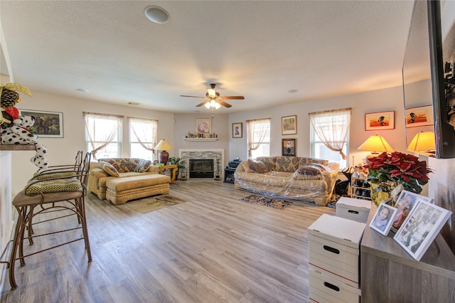 1414 Stevens Ct, Rosenberg, TX 77471 - living room with ceiling fan, healthy amount of natural light, a glass covered fireplace, and wood finished floors