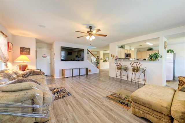 1414 Stevens Ct, Rosenberg, TX 77471 - living area featuring light wood-style flooring, a ceiling fan, stairway, and baseboards