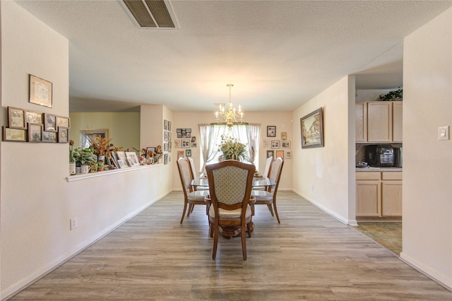 1414 Stevens Ct, Rosenberg, TX 77471 - dining space featuring a chandelier, light wood-style floors, and baseboards