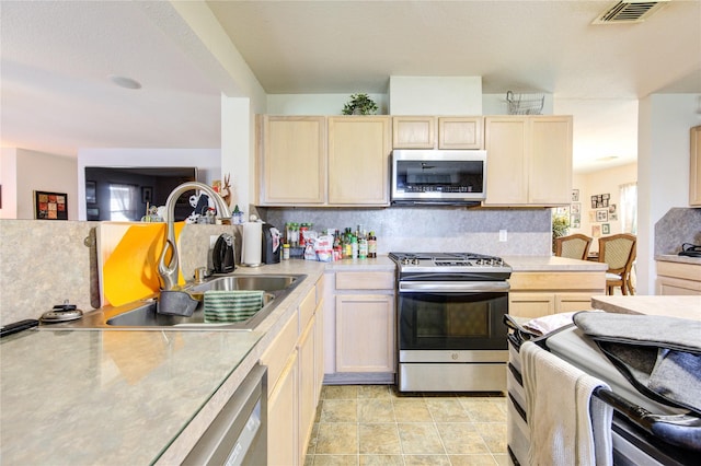 1414 Stevens Ct, Rosenberg, TX 77471 - kitchen with stainless steel appliances, light brown cabinetry, light countertops, tasteful backsplash, and a sink
