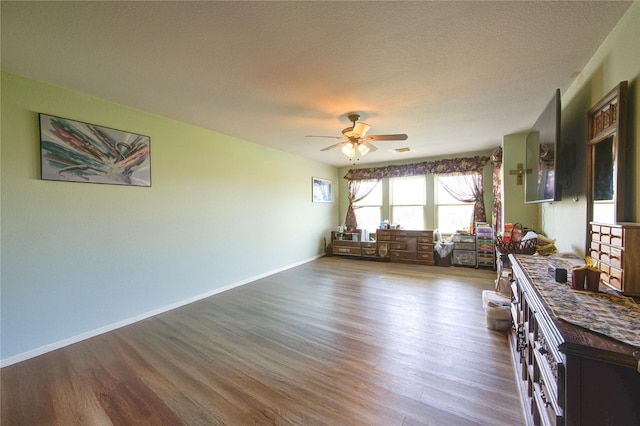 1414 Stevens Ct, Rosenberg, TX 77471 - living area with wood finished floors, a ceiling fan, baseboards, and a textured ceiling