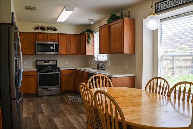 11831 Meadow Place Dr, Houston, TX 77071 - kitchen with appliances with stainless steel finishes, light countertops, brown cabinets, dark wood finished floors, and a sink