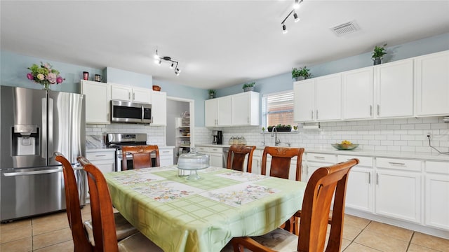 5923 W Harrow Dr, Houston, TX 77084 - dining area with light tile patterned floors and track lighting
