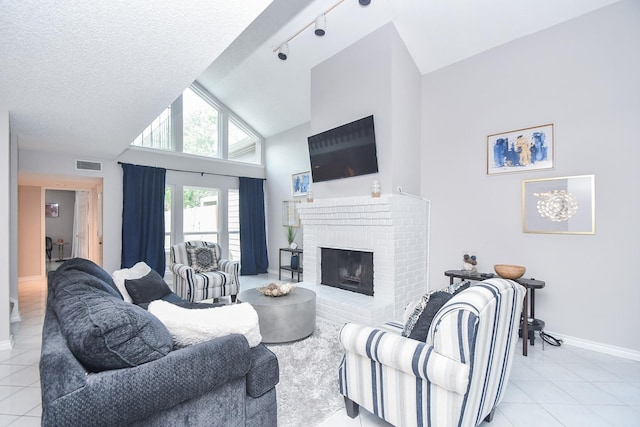 18143 Bal Harbour Dr, Houston, TX 77058 - living room with light tile patterned floors, a brick fireplace, baseboards, high vaulted ceiling, and a textured ceiling
