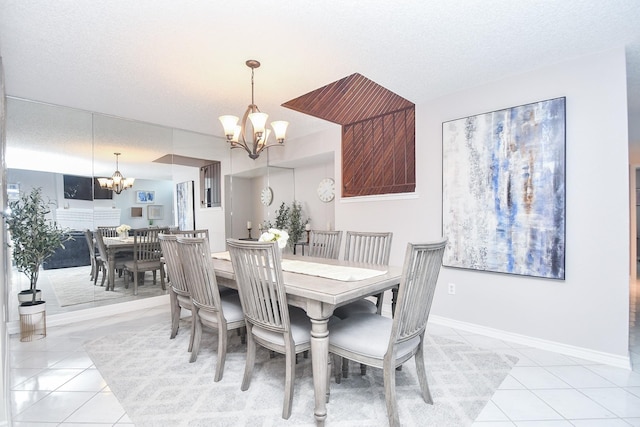 18143 Bal Harbour Dr, Houston, TX 77058 - dining space with a chandelier, light tile patterned flooring, baseboards, and a textured ceiling