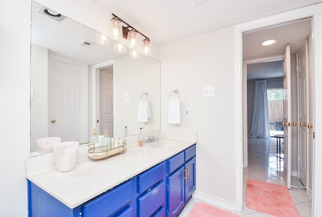 18143 Bal Harbour Dr, Houston, TX 77058 - bathroom with a textured ceiling, tile patterned flooring, baseboards, and vanity