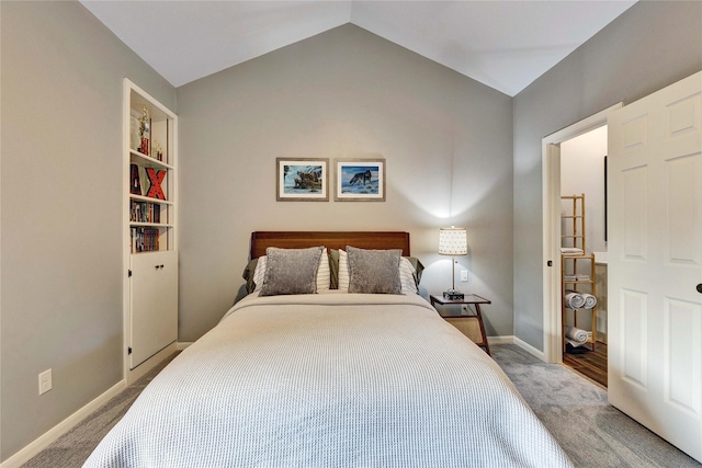 carpeted bedroom featuring lofted ceiling and baseboards