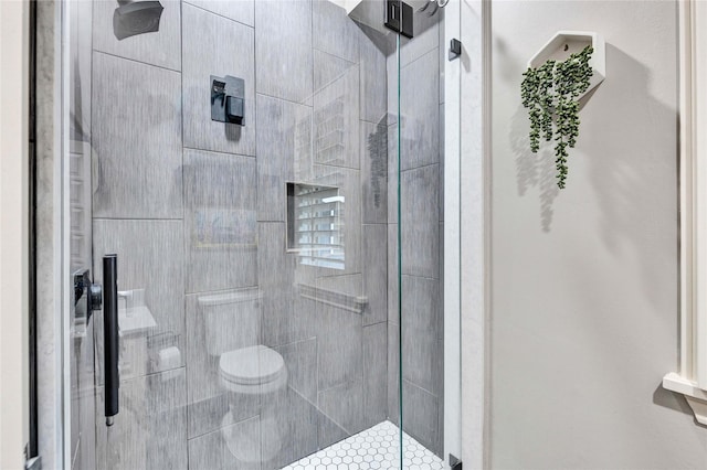full bathroom featuring a stall shower and toilet