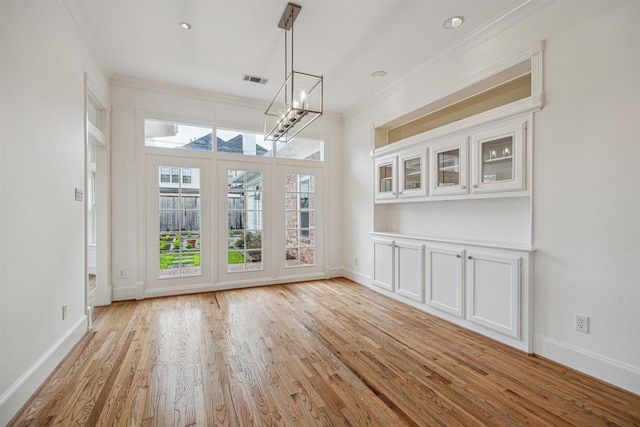 5302 Huisache St, Bellaire, TX 77401 - unfurnished dining area featuring a chandelier, light wood-style flooring, ornamental molding, and baseboards