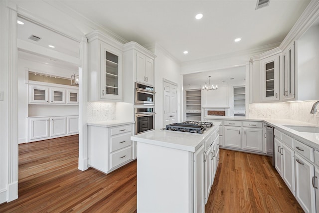 5302 Huisache St, Bellaire, TX 77401 - kitchen featuring a sink, stainless steel appliances, a chandelier, dark wood finished floors, and white cabinetry