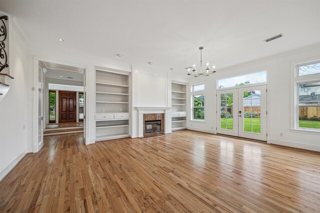 5302 Huisache St, Bellaire, TX 77401 - unfurnished living room with crown molding, light wood finished floors, a high end fireplace, a chandelier, and healthy amount of natural light