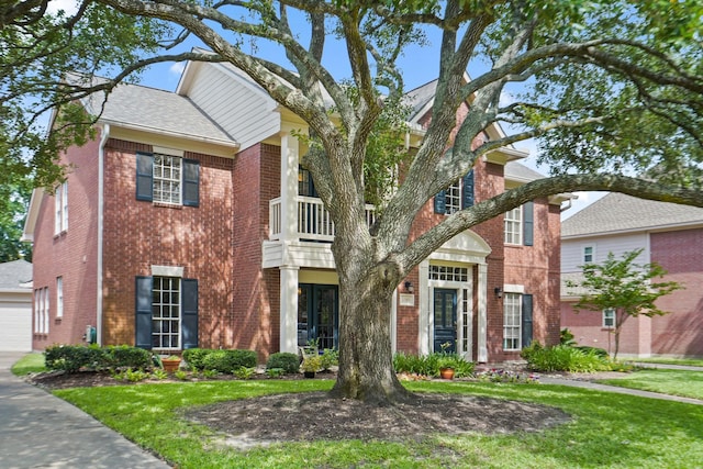 3303 Quiet Lake Dr, Katy, TX 77450 - traditional-style house with brick siding, a front lawn, a balcony, and a garage