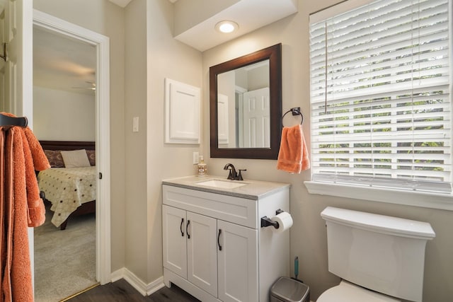 3303 Quiet Lake Dr, Katy, TX 77450 - bathroom with connected bathroom, wood finished floors, toilet, vanity, and baseboards