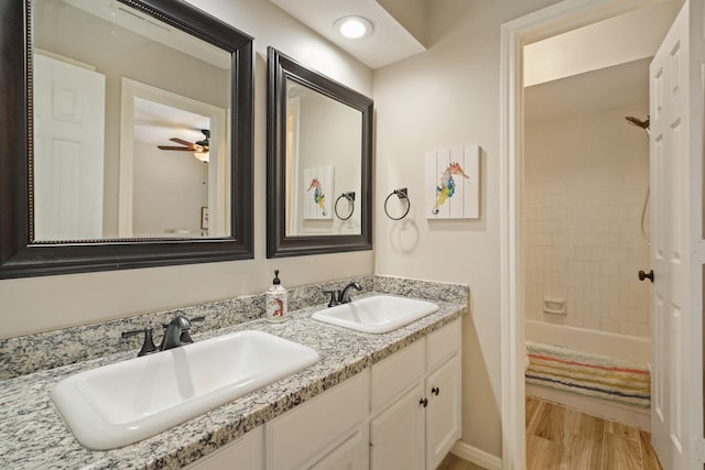 3303 Quiet Lake Dr, Katy, TX 77450 - bathroom with a ceiling fan, double vanity, bathtub / shower combination, and wood finished floors