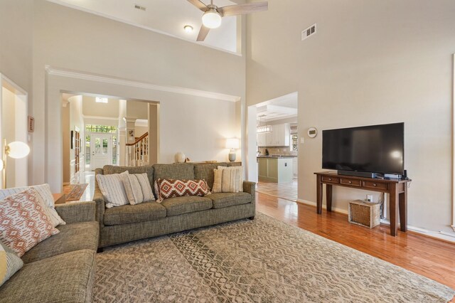 3303 Quiet Lake Dr, Katy, TX 77450 - living area with a ceiling fan, stairs, wood finished floors, a high ceiling, and crown molding