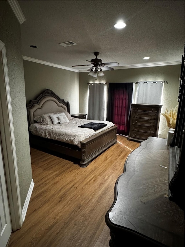 2514 Thunderbird Dr, Orange, TX 77630 - bedroom featuring ornamental molding, a textured wall, wood finished floors, a textured ceiling, and a ceiling fan
