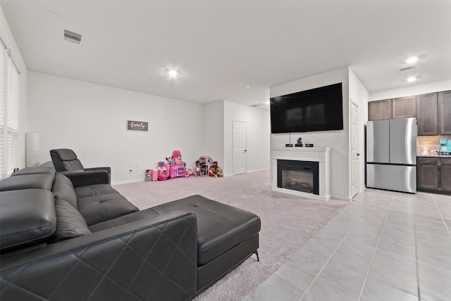 2897 Shimmer Edge Dr, Katy, TX 77493 - living area featuring recessed lighting, light tile patterned floors, a glass covered fireplace, baseboards, and light carpet