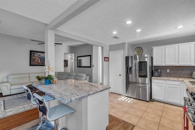 16222 Indian Cypress Dr, Cypress, TX 77429 - kitchen featuring appliances with stainless steel finishes, a breakfast bar area, white cabinets, light stone counters, and recessed lighting