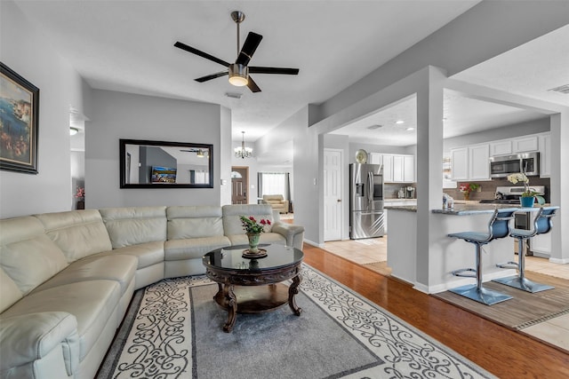 16222 Indian Cypress Dr, Cypress, TX 77429 - living room with light wood-style flooring, a ceiling fan, and a chandelier