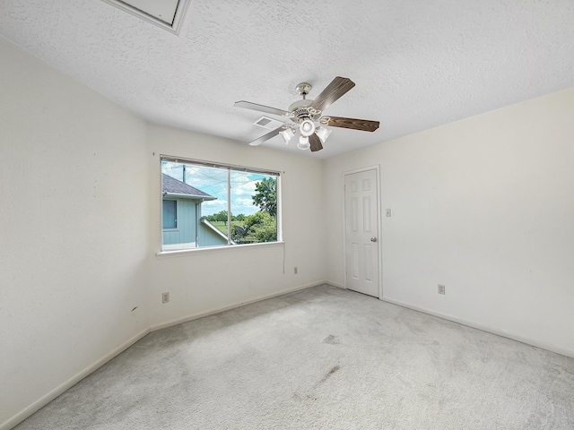 empty room featuring carpet, a textured ceiling, a ceiling fan, and baseboards