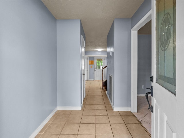 10218 Sagerock Dr, Houston, TX 77089 - hall featuring light tile patterned floors, a textured ceiling, and baseboards