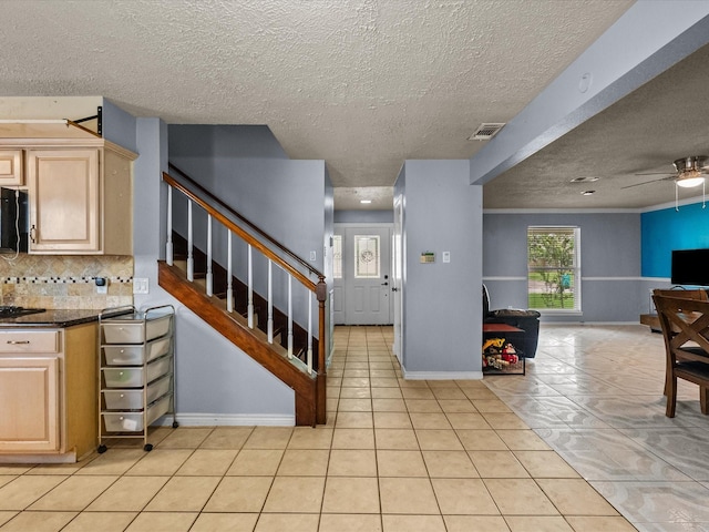 10218 Sagerock Dr, Houston, TX 77089 - kitchen featuring open floor plan, light tile patterned floors, ceiling fan, light brown cabinetry, and a textured ceiling