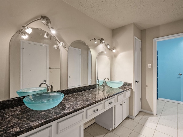 10218 Sagerock Dr, Houston, TX 77089 - full bath featuring double vanity, tile patterned floors, a textured ceiling, and baseboards