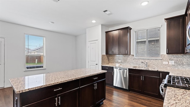 321 Lippizan Dr, Alvin, TX 77511 - kitchen featuring stainless steel appliances, a sink, decorative backsplash, dark brown cabinetry, and light stone counters