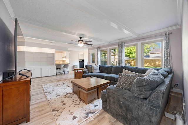 7906 Beaufort Dr, Spring, TX 77379 - living room with crown molding, a ceiling fan, a textured ceiling, and light wood-style floors