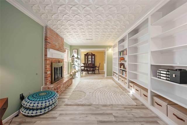 7906 Beaufort Dr, Spring, TX 77379 - living room featuring ornamental molding, an ornate ceiling, built in shelves, a brick fireplace, and baseboards