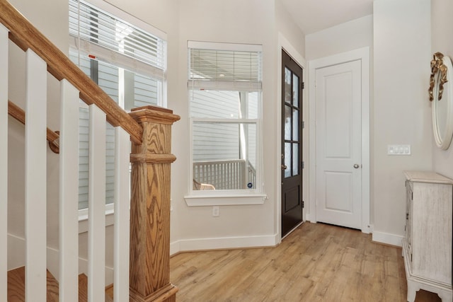 entryway featuring light wood-type flooring, baseboards, and healthy amount of natural light