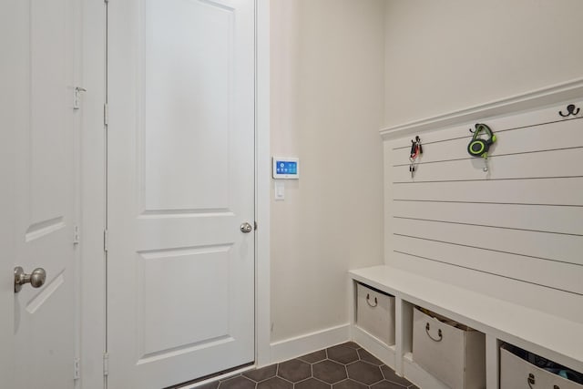 mudroom featuring dark tile patterned floors and baseboards