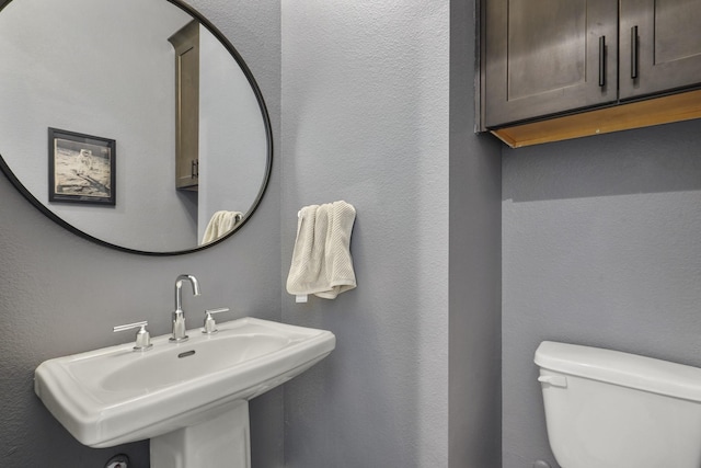 half bathroom featuring toilet and a sink