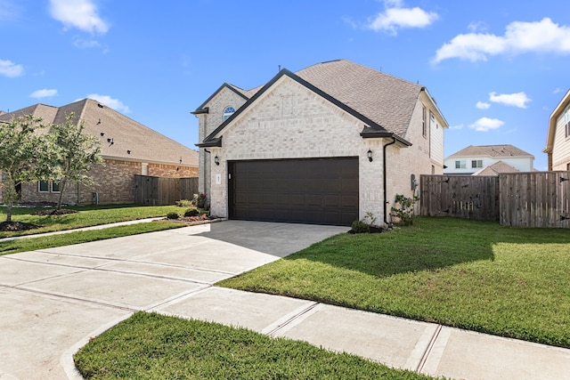 french provincial home with an attached garage, driveway, and brick siding