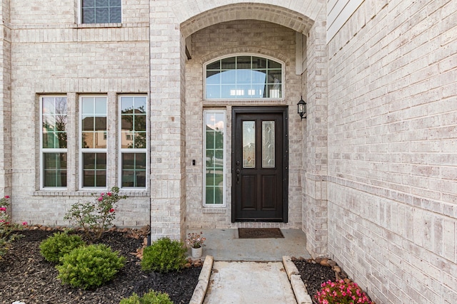 property entrance featuring brick siding