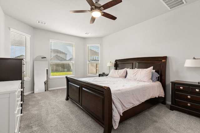 bedroom featuring light colored carpet, baseboards, and a ceiling fan