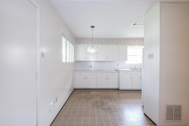 1902 S Memorial Ct, Pasadena, TX 77502 - kitchen featuring light countertops, white cabinets, light flooring, pendant lighting, and a sink