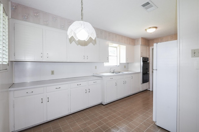 1902 S Memorial Ct, Pasadena, TX 77502 - kitchen featuring light countertops, tile patterned floors, white cabinets, a sink, and decorative light fixtures