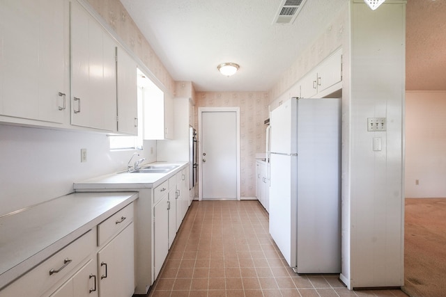 1902 S Memorial Ct, Pasadena, TX 77502 - kitchen with freestanding refrigerator, a sink, light countertops, white cabinetry, and stainless steel double oven