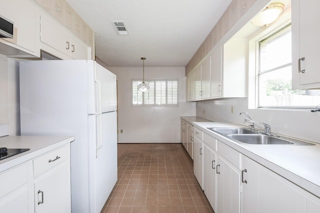 1902 S Memorial Ct, Pasadena, TX 77502 - kitchen featuring a sink, light countertops, white cabinetry, decorative light fixtures, and freestanding refrigerator