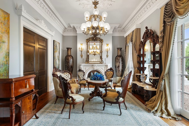 sitting room with a chandelier, wood-type flooring, crown molding, and a raised ceiling