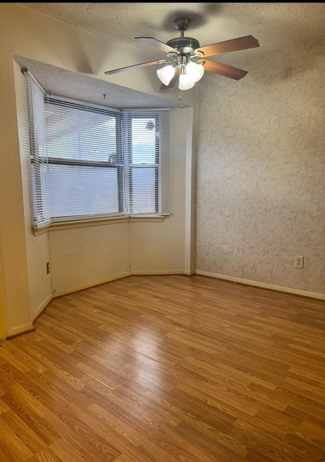 13424 Castilian Dr Unit 113, Houston, TX 77015 - unfurnished room featuring light wood-type flooring, baseboards, a ceiling fan, and a textured ceiling